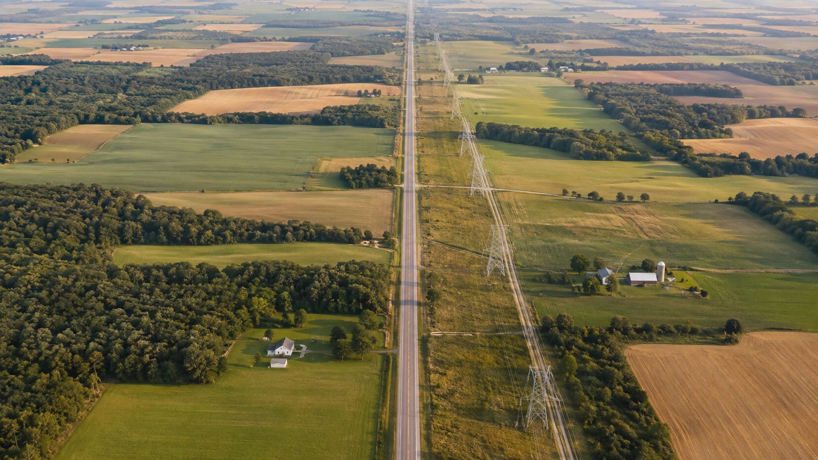 Data Centers Impact on Land: 8 Risks for Buyers 12 Aerial view of a straight road and power lines cutting through a vast rural landscape.
